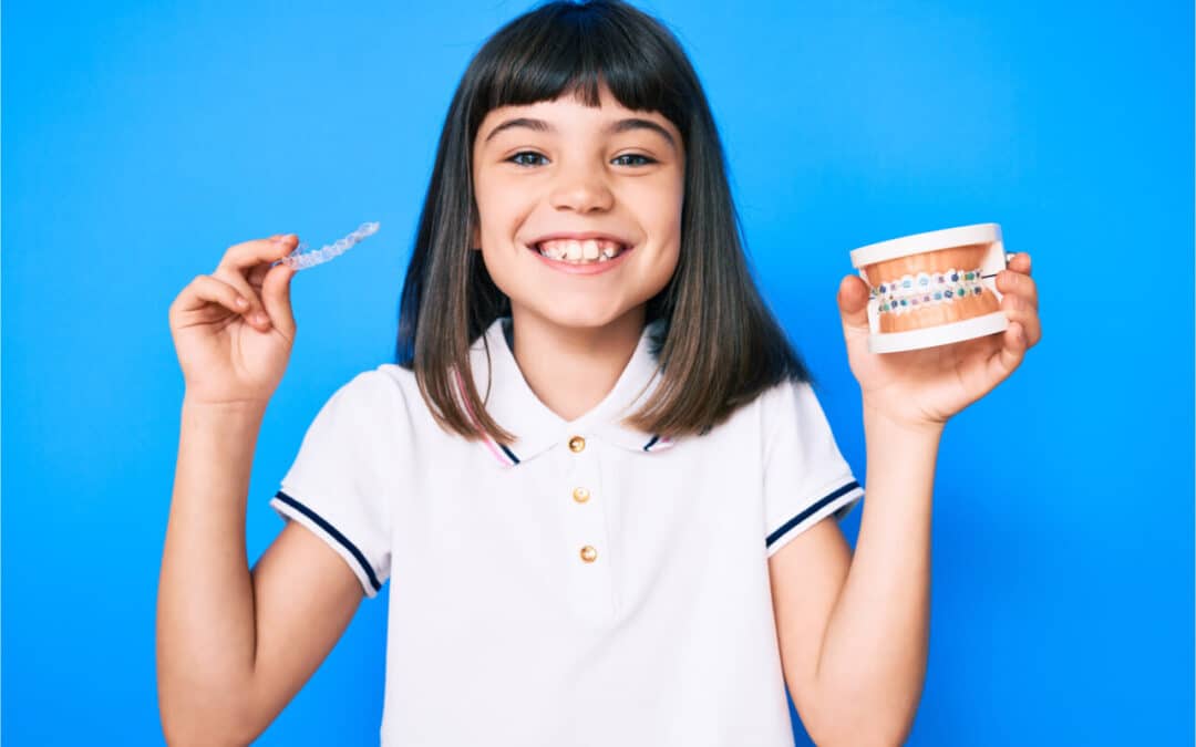 The child is holding two kinds of dental braces.